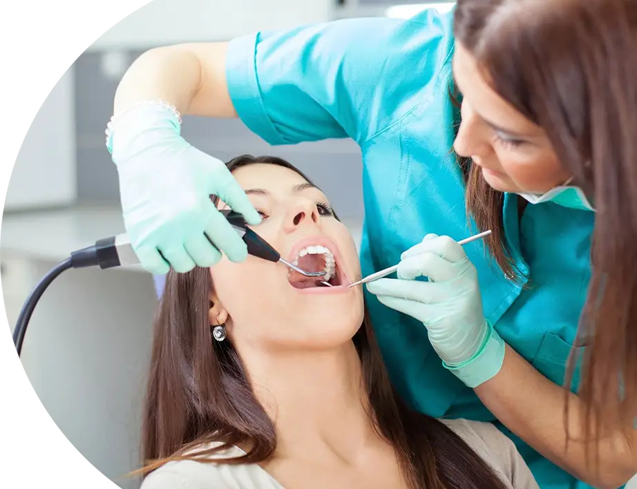 A woman getting her teeth checked by an dentist.