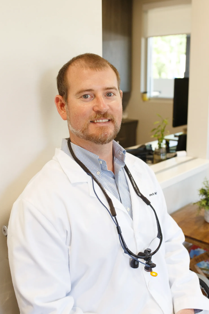 A man in white lab coat with stethoscope around neck.