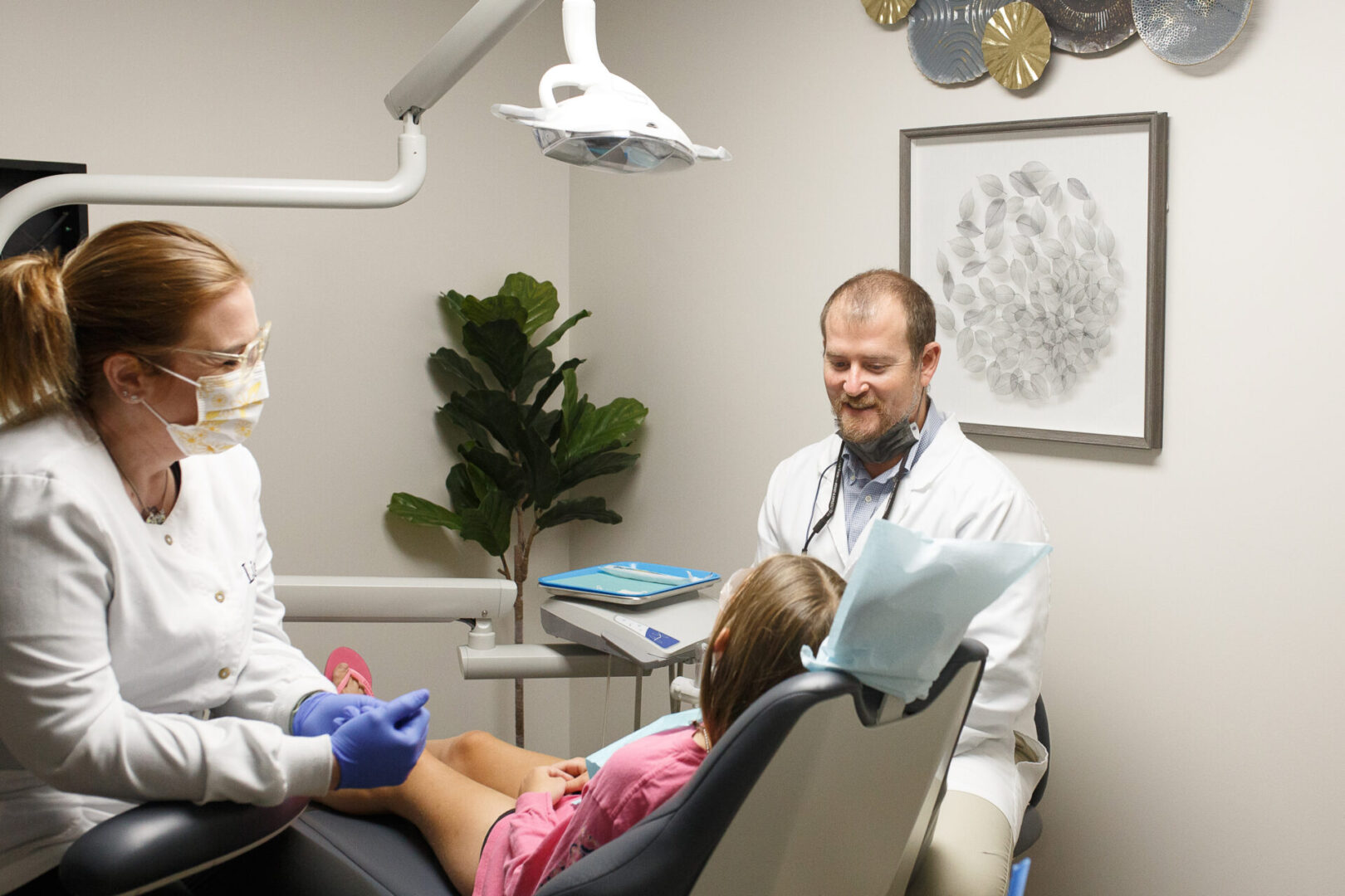 A dentist and his assistant are examining the patient.