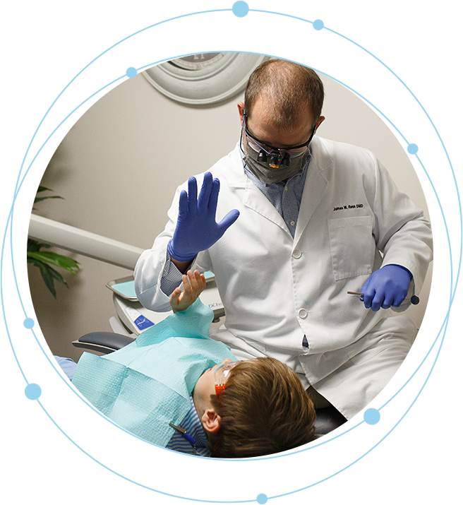 A dentist is examining the teeth of a young boy.