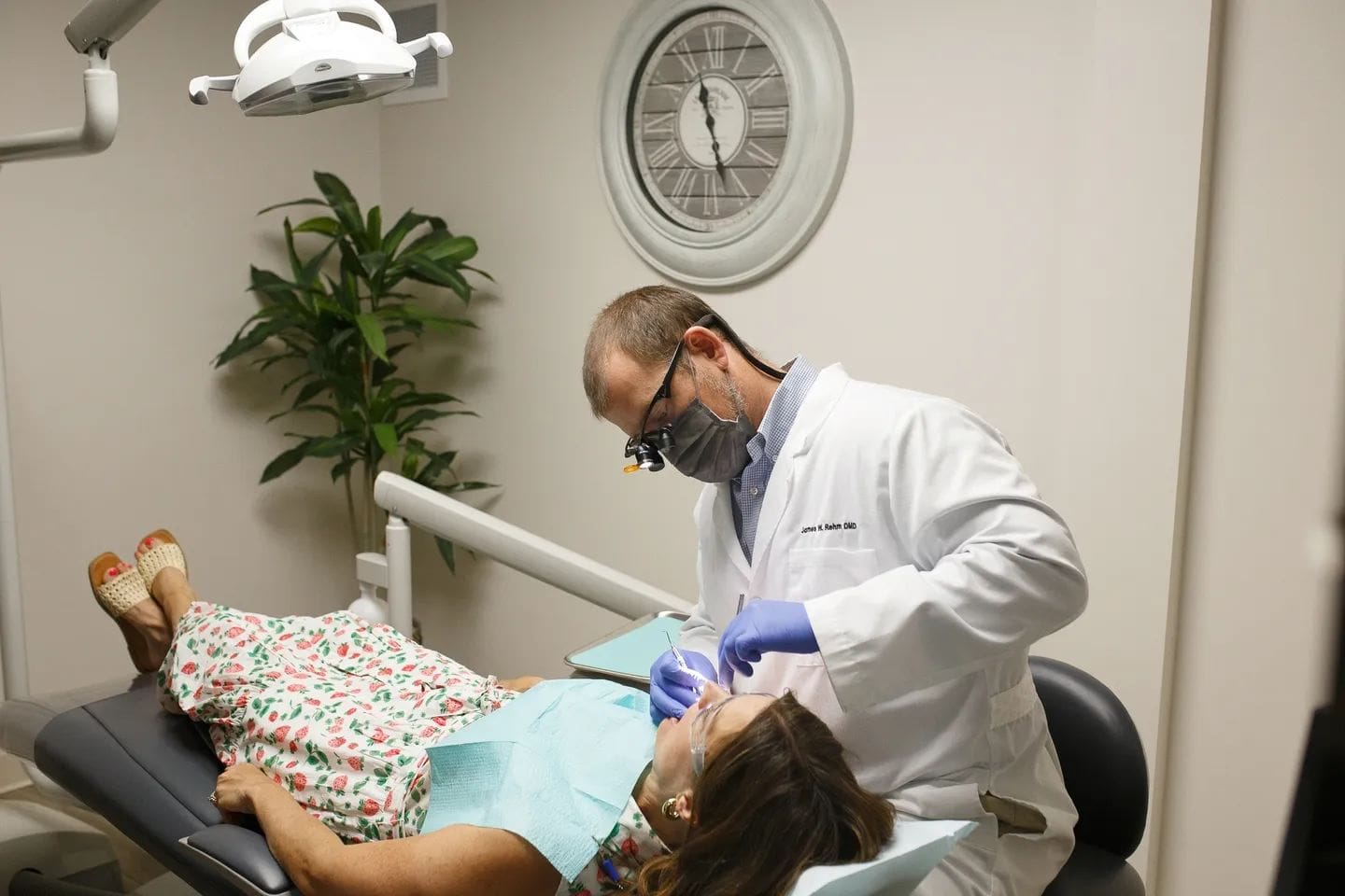 A dentist is examining the patient 's teeth.