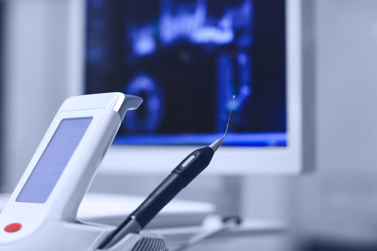 A tooth brush and mirror in front of a computer screen.