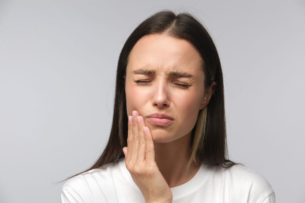 A woman holding her face in front of the camera.