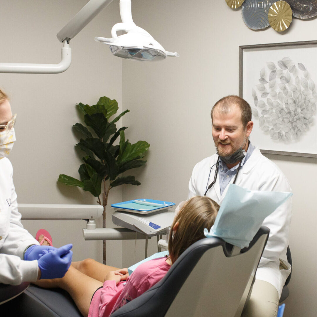 A dentist and his assistant are examining the patient.